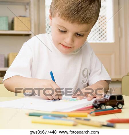 Stock Photo - Close-up of a boy drawing on a sheet of paper. Fotosearch