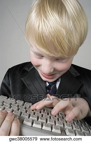 Close-up of a boy holding a computer keyboard View Large Photo Image Stock Photo - Close-up of a boy holding a computer keyboard. Fotosearch