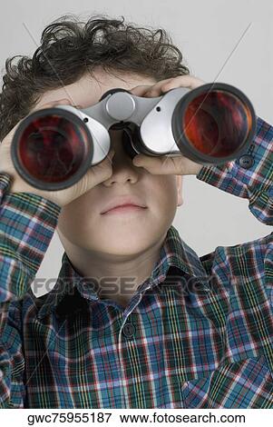 Close-up of a boy looking through a pair of binoculars View Large Photo Image Stock Photo - Close-up of a boy looking through a pair of binoculars. Fotosearch