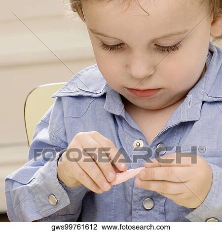 Close-up of a boy sitting on a chair View Large Photo Image Stock Image - Close-up of a boy sitting on a chair. Fotosearch