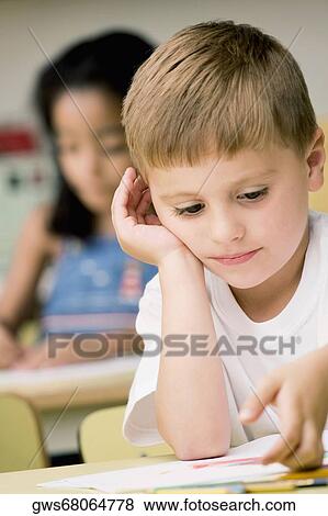 Close-up of a boy thinking with a girl sitting behind him View Large Photo Image Stock Photo - Close-up of a boy thinking with a girl sitting behind him. Fotosearch