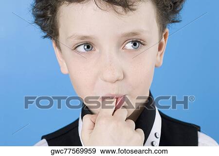Close-up of a boy with his finger in his mouth View Large Photo Image Stock Photo - Close-up of a boy with his finger in his mouth. Fotosearch