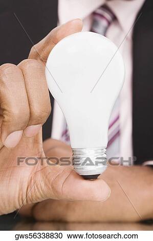 Close-up of a businessman holding a light bulb View Large Photo Image Stock Image - Close-up of a businessman holding a light bulb. Fotosearch