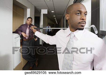 Stock Photography - Close-up of a businessman holding a golf club. Fotosearch