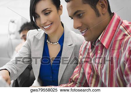 Close-up of a businessman looking at a laptop with a businesswoman and smiling View Large Photo Image Stock Photography - Close-up of a businessman looking at a laptop with a businesswoman and smiling. Fotosearch