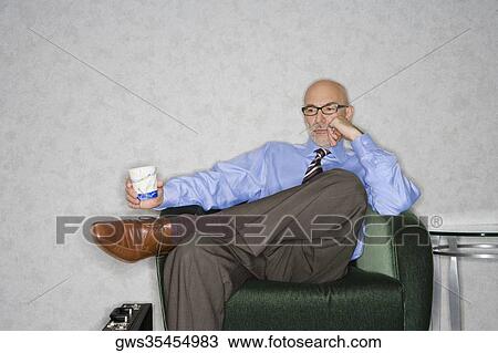 Stock Image - Close-up of a businessman sitting in an armchair and thinking. Fotosearch