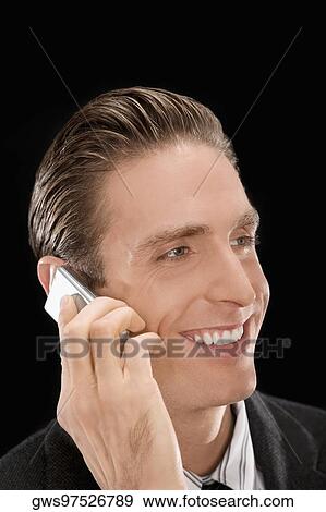 Stock Photo - Close-up of a businessman talking on a mobile phone and smiling. Fotosearch