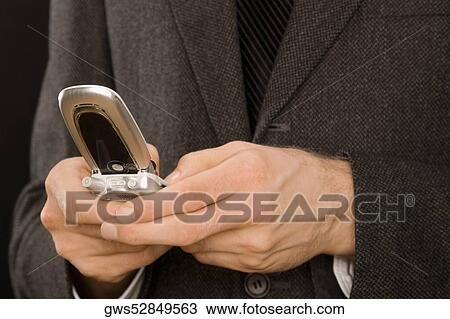 Stock Image - Close-up of a businessman text messaging. Fotosearch