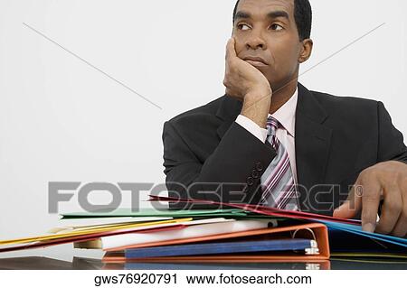 Stock Image - Close-up of a businessman thinking with his hand on his chin. Fotosearch