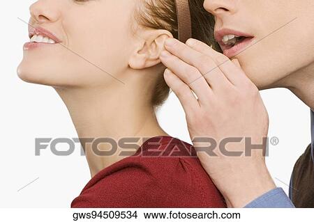 Close-up of a businessman whispering into a businesswoman's ear View Large Photo Image Picture - Close-up of a businessman whispering into a businesswoman's ear. Fotosearch