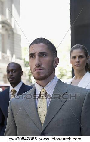 Close-up of a businessman with two business executives standing behind him View Large Photo Image Stock Photography - Close-up of a businessman with two business executives standing behind him. Fotosearch