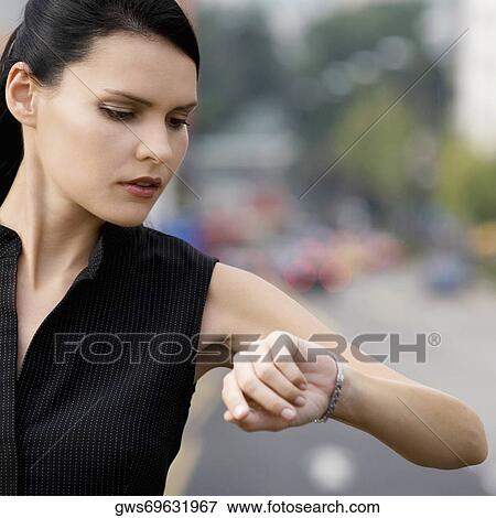 Close-up of a businesswoman checking the time View Large Photo Image Stock Photo - Close-up of a businesswoman checking the time. Fotosearch