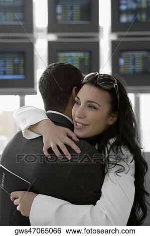 Close-up of a businesswoman embracing a businessman at an airport View Large Photo Image Stock Photograph - Close-up of a businesswoman embracing a businessman at an airport. Fotosearch