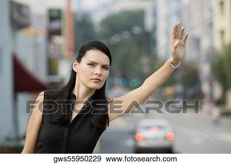 Close-up of a businesswoman hailing for a vehicle View Large Photo Image Stock Photo - Close-up of a businesswoman hailing for a vehicle. Fotosearch