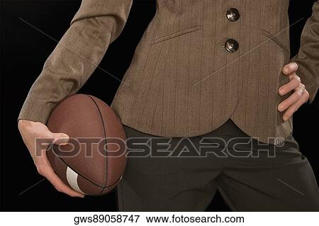 Close-up of a businesswoman holding an American football View Large Photo Image Stock Photo - Close-up of a businesswoman holding an American football. Fotosearch