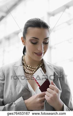 Close-up of a businesswoman putting a passport and an airplane ticket in her pocket View Large Photo Image Stock Photo - Close-up of a businesswoman putting a passport and an airplane ticket in her pocket. Fotosearch