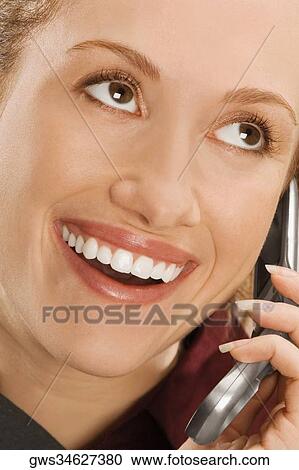 Close-up of a businesswoman talking on a mobile phone and smiling View Large Photo Image Stock Image - Close-up of a businesswoman talking on a mobile phone and smiling. Fotosearch