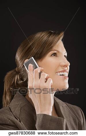Stock Photo - Close-up of a businesswoman talking on a mobile phone and smiling. Fotosearch