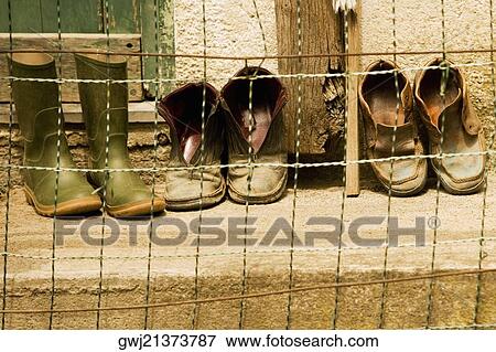 Stock Photo - Close-up of a chain-link fence in front of shoes, Italian Riviera, Cinque Terre National Park, Vernazza, La Spezia, Liguria, Italy. Fotosearch