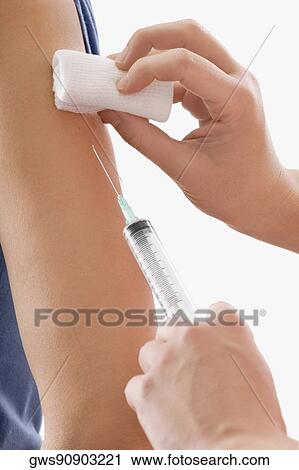 Stock Image - Close-up of a doctor giving injection to a patient. Fotosearch