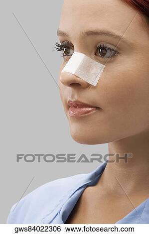 Close-up of a female patient with an adhesive bandage on her nose View Large Photo Image Stock Photograph - Close-up of a female patient with an adhesive bandage on her nose. Fotosearch