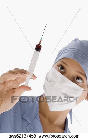 Close-up of a female surgeon holding a syringe View Large Photo Image Stock Photo - Close-up of a female surgeon holding a syringe. Fotosearch