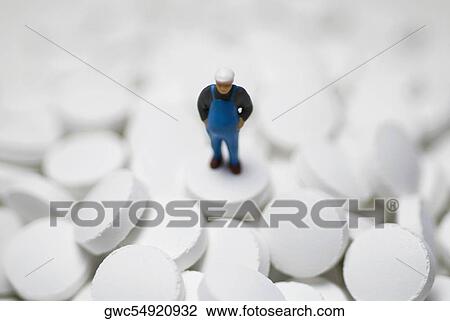 Stock Image - Close-up of a figurine on the heap of pills. Fotosearch