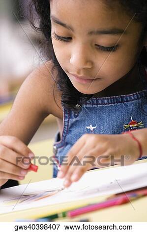 Stock Photo - Close-up of a girl drawing in a coloring book. Fotosearch