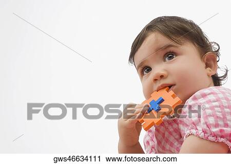 Stock Image - Close-up of a girl holding a toy. Fotosearch