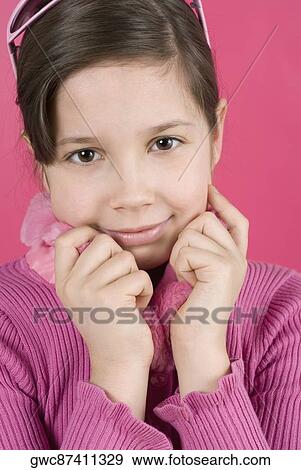 Stock Photo - Close-up of a girl holding her sweater and smiling. Fotosearch