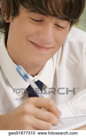 Stock Image - Close-up of a high school student writing in a notebook. Fotosearch