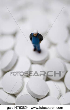 Close-up of a human figurine on the heap of pills View Large Photo Image Picture - Close-up of a human figurine on the heap of pills. Fotosearch