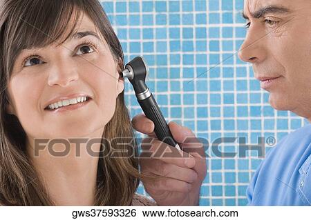 Close-up of a male doctor examining a mature woman's ear View Large Photo Image Stock Photograph - Close-up of a male doctor examining a mature woman's ear. Fotosearch