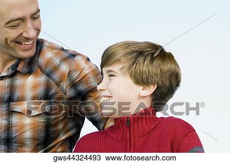 Close-up of a mid adult man with his son smiling View Large Photo Image Stock Image - Close-up of a mid adult man with his son smiling. Fotosearch