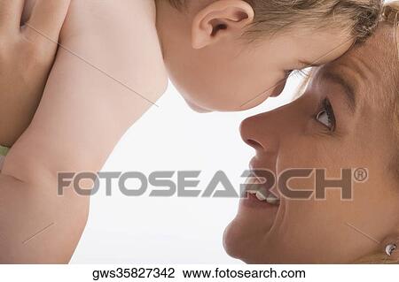 Stock Image - Close-up of a mid adult woman looking at her son and smiling. Fotosearch