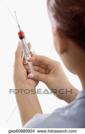 Close-up of a person holding a syringe View Large Photo Image Picture - Close-up of a person holding a syringe. Fotosearch
