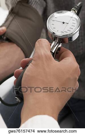 Close-up of a person's hand checking a patient's blood pressure View Large Photo Image Picture - Close-up of a person's hand checking a patient's blood pressure. Fotosearch