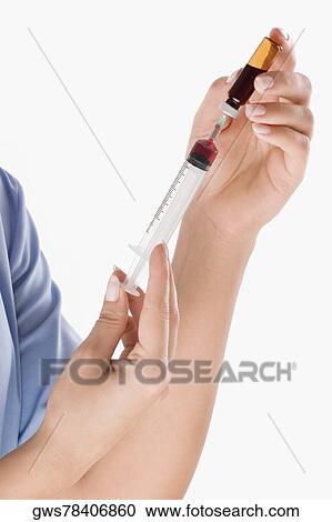 Close-up of a person's hand filling an injection from a vial View Large Photo Image Stock Image - Close-up of a person's hand filling an injection from a vial. Fotosearch