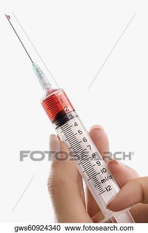 Close-up of a person's hand holding a syringe View Large Photo Image Stock Image - Close-up of a person's hand holding a syringe. Fotosearch
