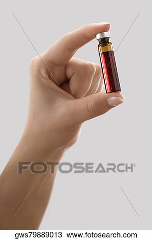 Close-up of a person's hand holding a vial View Large Photo Image Stock Image - Close-up of a person's hand holding a vial. Fotosearch
