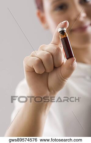 Close-up of a person's hand holding a vial View Large Photo Image Stock Photograph - Close-up of a person's hand holding a vial. Fotosearch