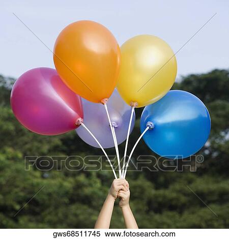 Close-up of a person's hand holding balloons View Large Photo Image Stock Photography - Close-up of a person's hand holding balloons. Fotosearch
