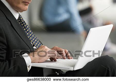Stock Image - Close-up of a professor using a laptop in a corridor. Fotosearch