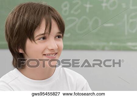 Close-up of a schoolboy smiling in a classroom View Large Photo Image Stock Photo - Close-up of a schoolboy smiling in a classroom. Fotosearch
