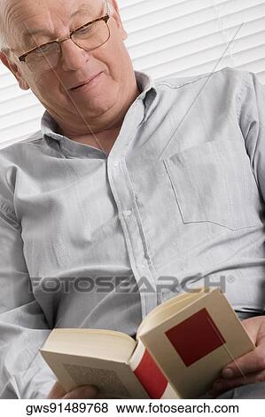 Stock Photo - Close-up of a senior man reading a book. Fotosearch