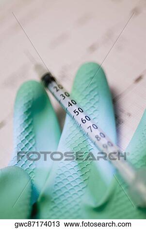 Close-up of a syringe with a glove View Large Photo Image Stock Image - Close-up of a syringe with a glove. Fotosearch