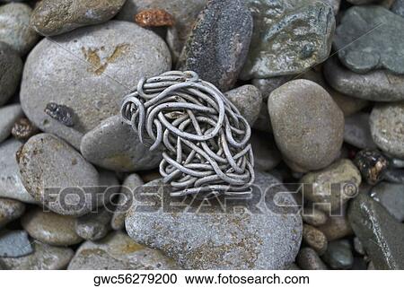 Close-up of a tangled aluminum wire on pebbles View Large Photo Image Stock Image - Close-up of a tangled aluminum wire on pebbles. Fotosearch