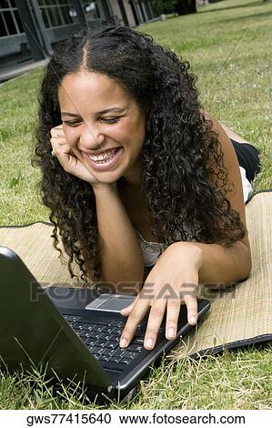 Close-up of a teenage girl using a laptop and smiling View Large Photo Image Stock Image - Close-up of a teenage girl using a laptop and smiling. Fotosearch