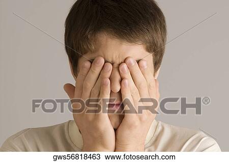 Close-up of a young man covering his eyes with his hands View Large Photo Image Stock Image - Close-up of a young man covering his eyes with his hands. Fotosearch