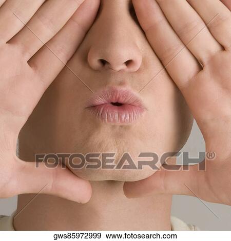 Stock Photo - Close-up of a young man covering his eyes with his hands. Fotosearch